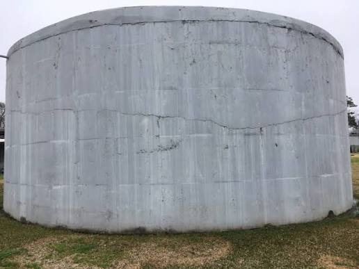 Vertical cracking and surface streaking on a concrete tank wall