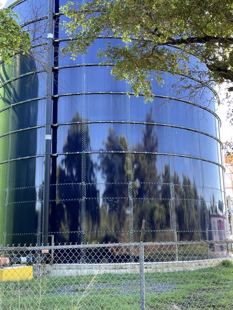 Technician inspecting the exterior shell of a bolted steel tank