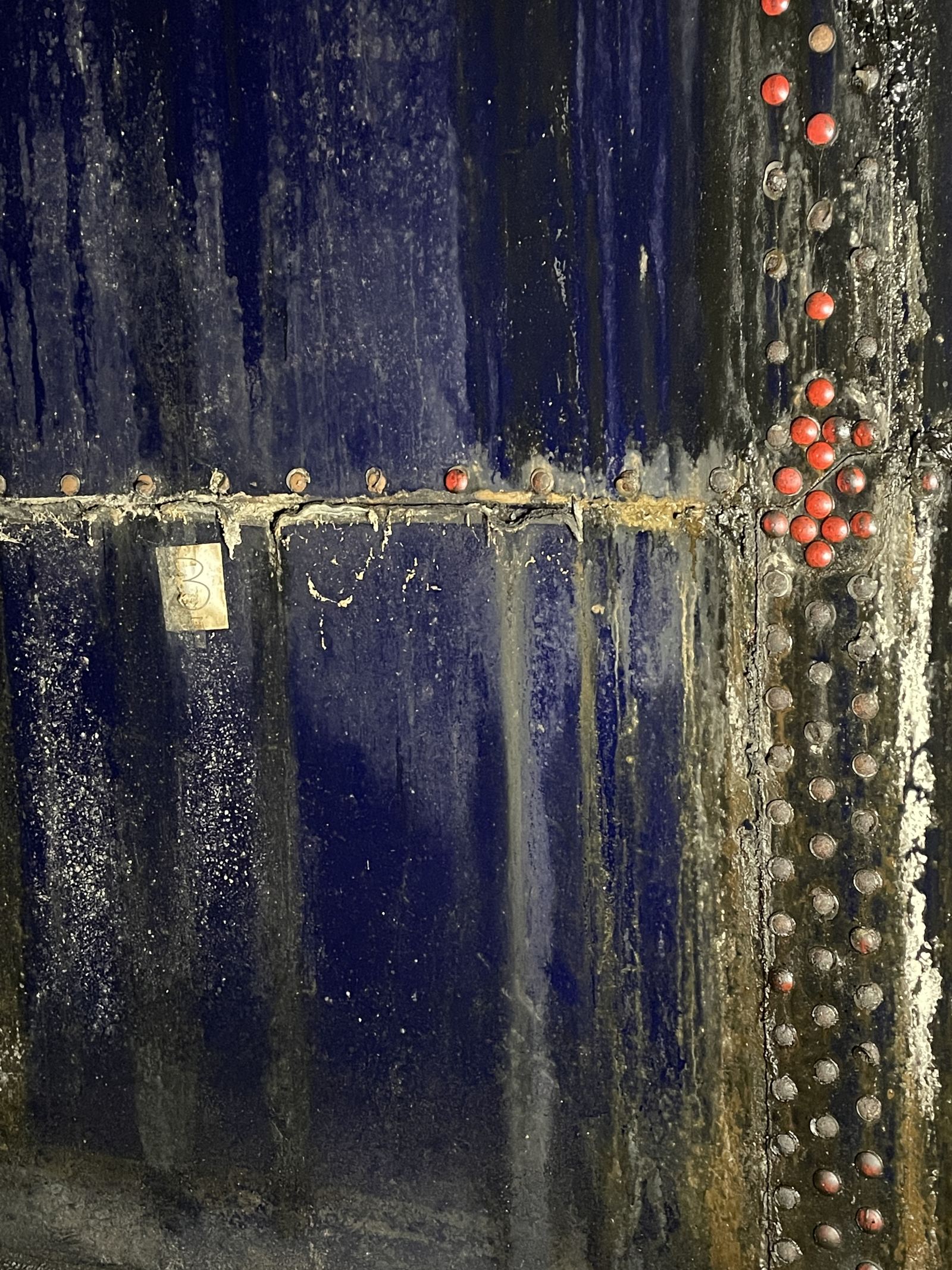 Interior bolted-tank wall showing advanced corrosion from a coating-to-service mismatch