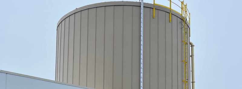 Storage tank clad in a vertical standing seam insulation system