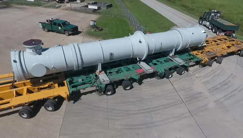 Large ASME shell-and-tube heat exchanger loaded on a multi-axle transport trailer for shipment from the fabrication shop