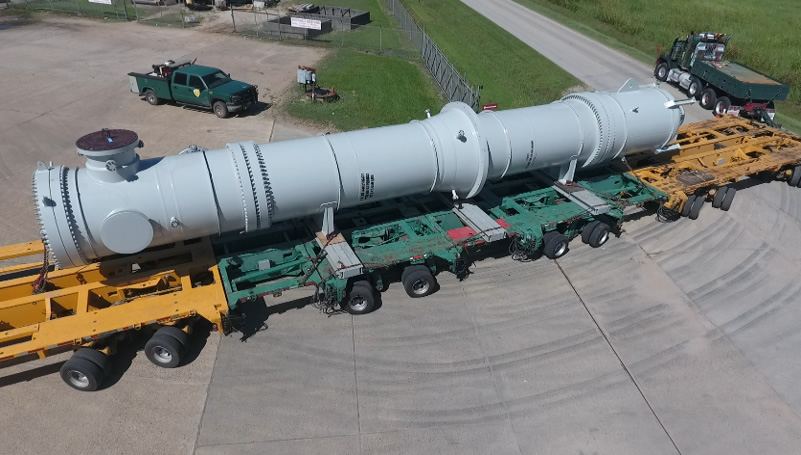 Completed shell-and-tube heater loaded on a multi-axle transport trailer outside the fabrication shop