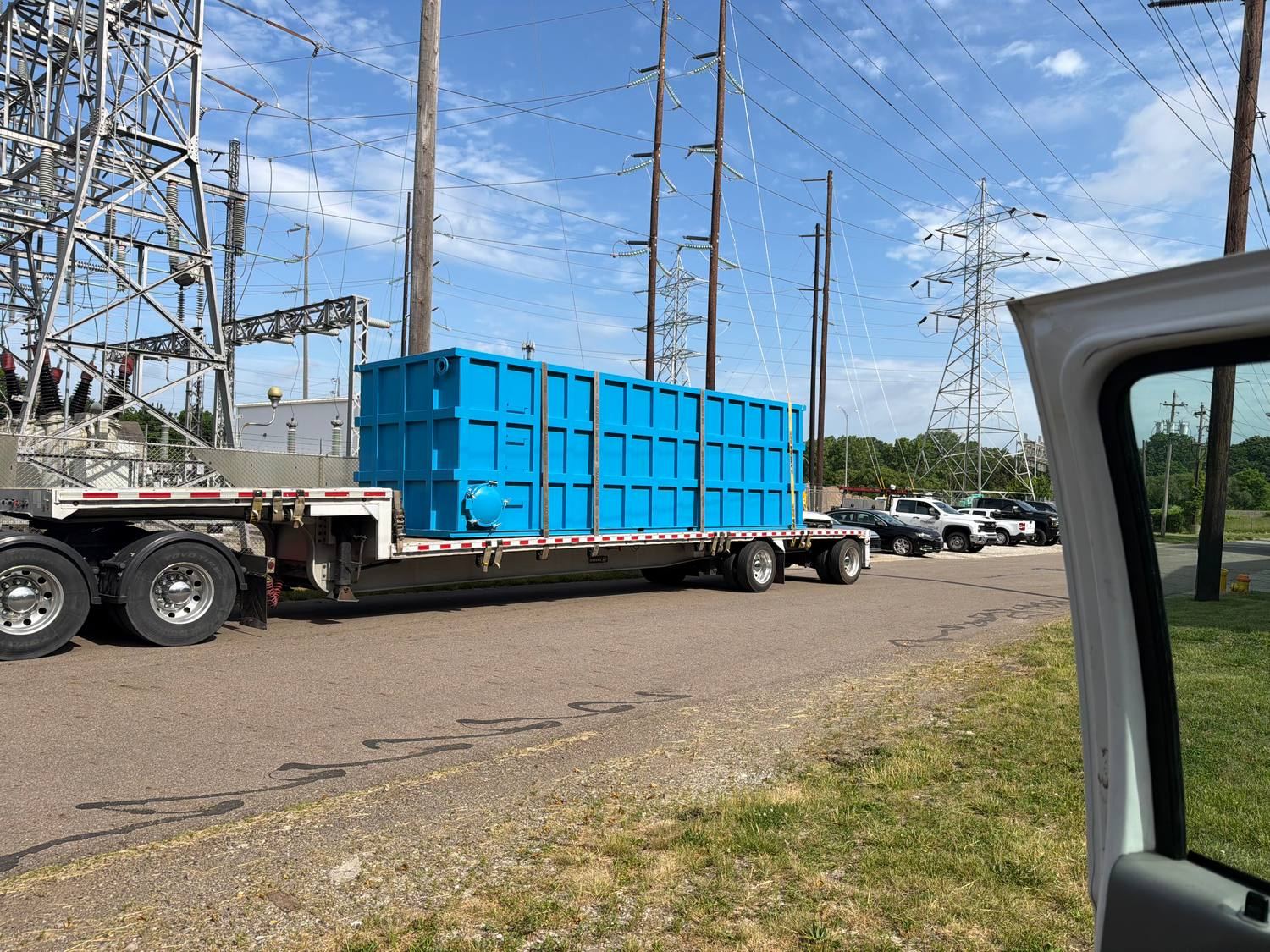 Blue shop-welded steel tank loaded on a flatbed trailer, coated and ready to ship from the plant