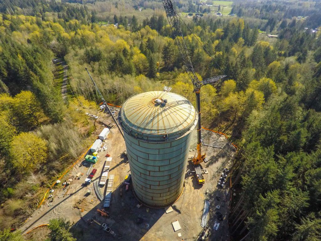 Field-welded steel standpipe under construction with a crane