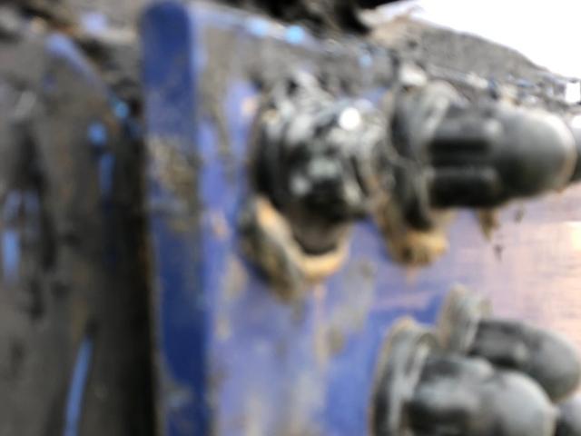 Corroded bolt heads and bolt caps on a bolted steel tank panel