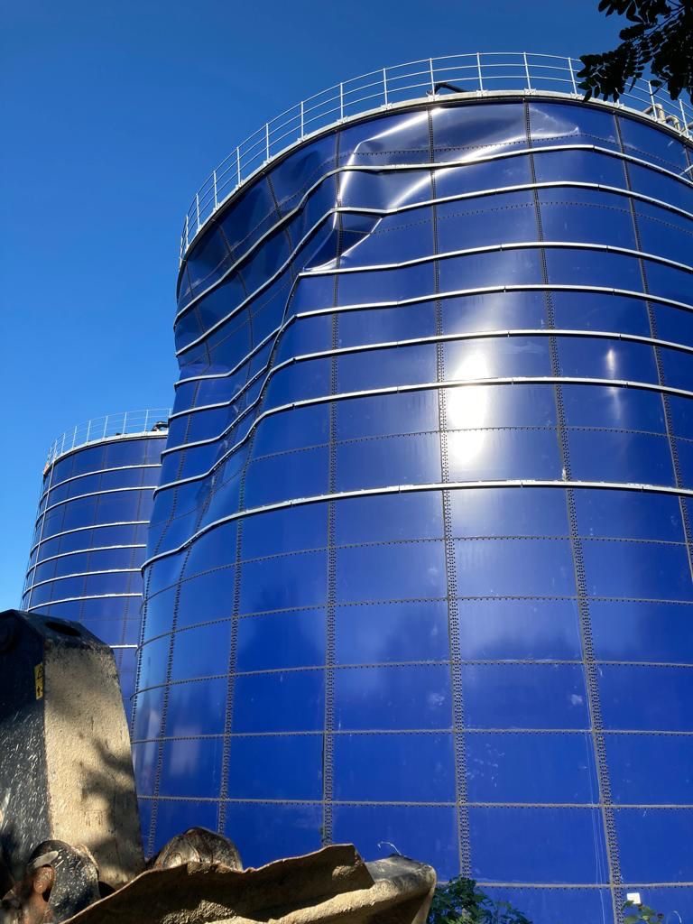 Technician inspecting bolted steel storage tanks